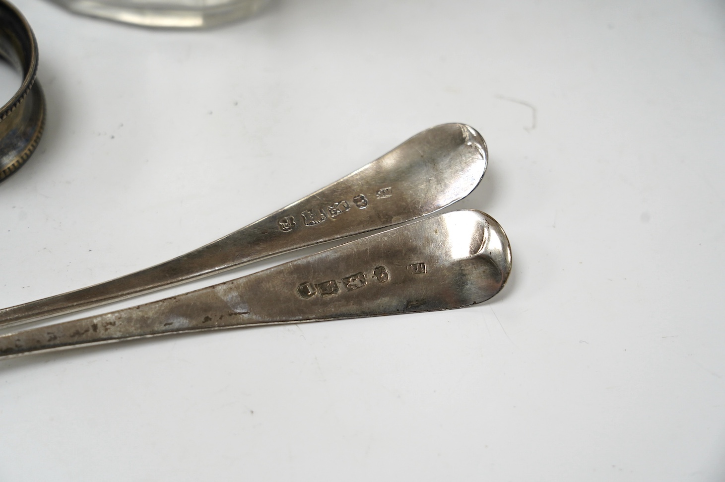 Two George III provincial silver Exeter table spoons, 22cm, two silver napkin rings and two silver mounted glass toilet jars. Condition - poor to fair